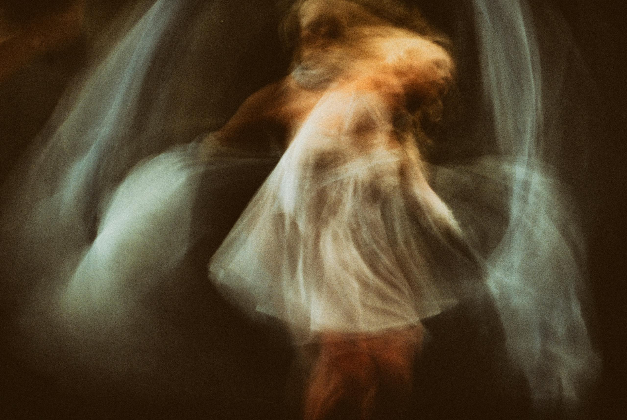 Abstract motion blur capture of a woman dancing, evoking ethereal and artistic expression.